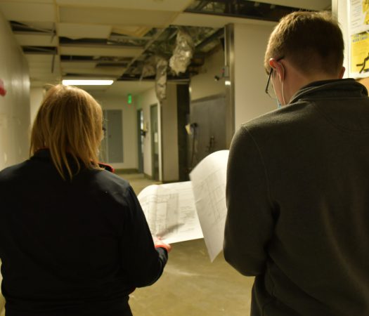 IP Design Group employees discuss drawings on site during an audio testing trip.